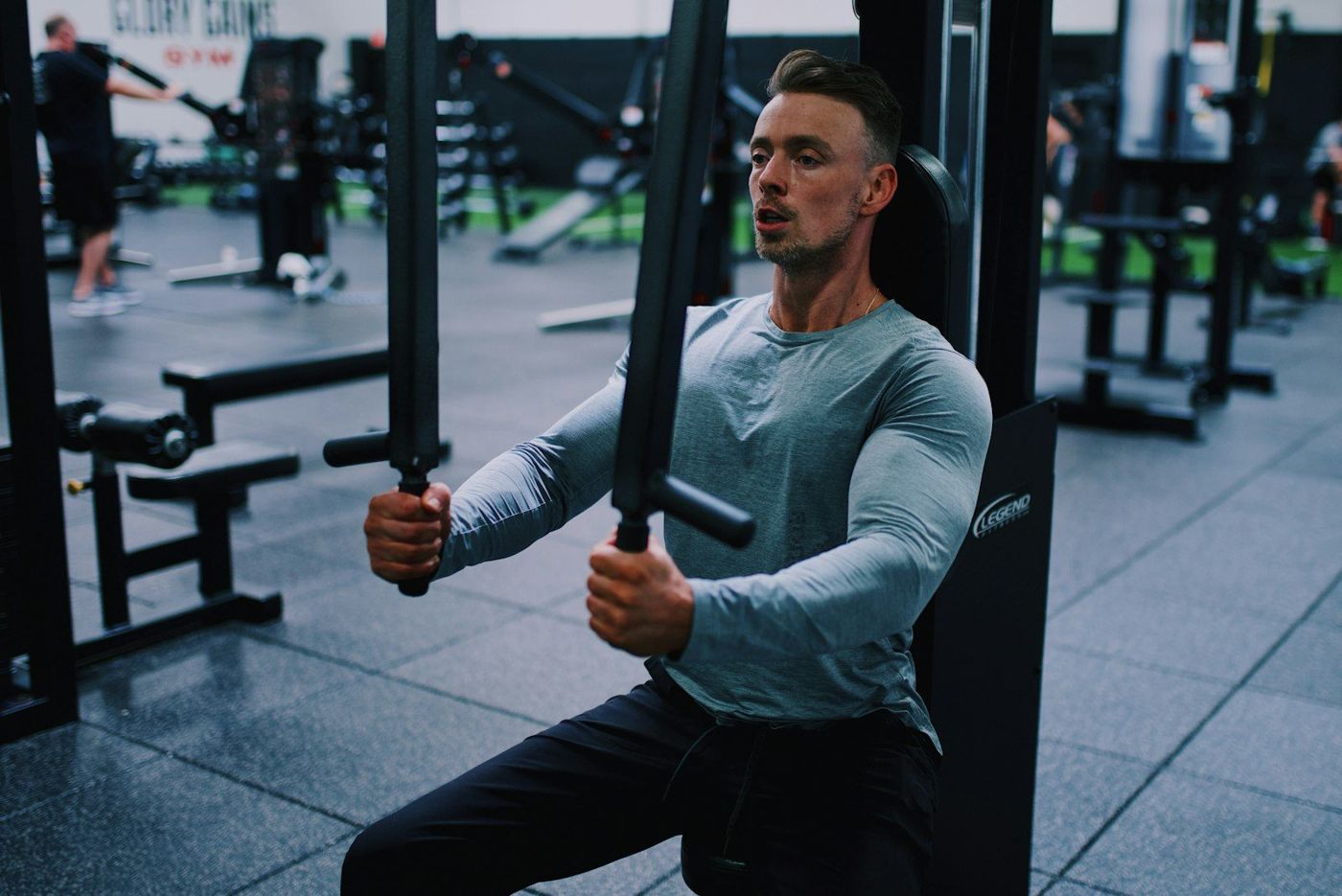 Imagen de referencia: hombre entrenando en una polea de gimnasio